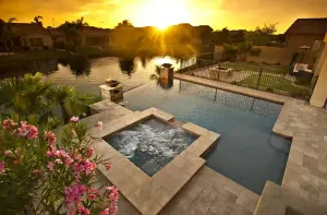 Custom pool remodel with square hot tub, travertine deck, and sunset views